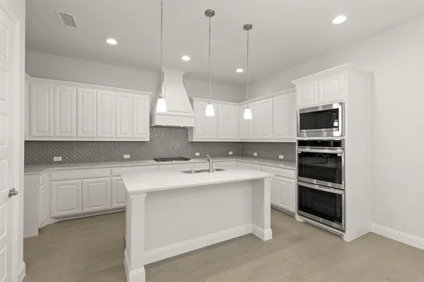 a kitchen with kitchen island a sink stainless steel appliances and cabinets