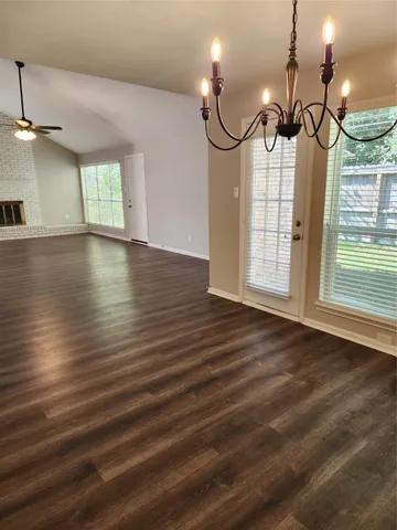 en empty room with wooden floor fan and windows