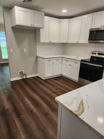 a view of a house with a yard and wooden fence