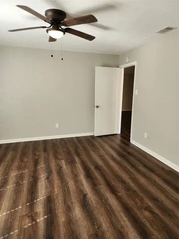 a view of a livingroom with a large window wooden floor and a ceiling fan
