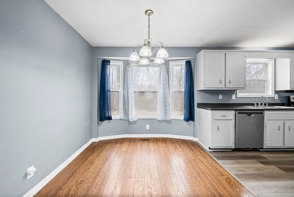 a view of a kitchen with granite countertop white cabinets and wooden floor