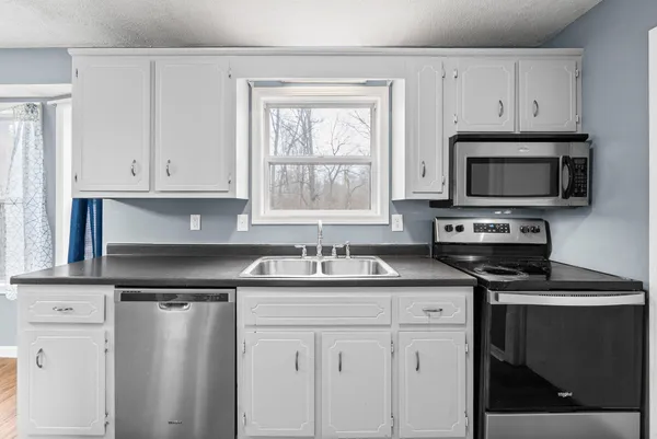 a kitchen with a sink stove and microwave