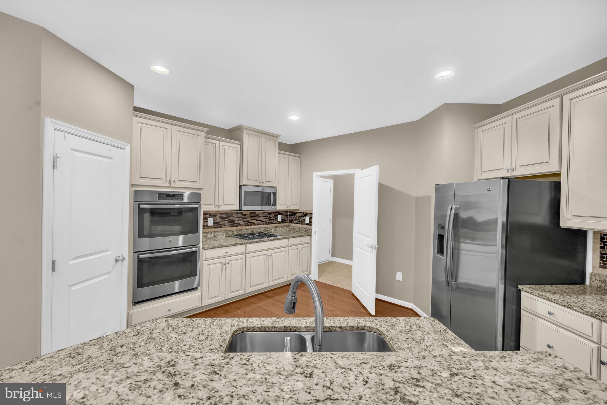 41663 McMonagle Square Aldie, VA 20105 - Photo 16 of 50 a kitchen with stainless steel appliances kitchen island granite countertop a refrigerator and a stove top oven