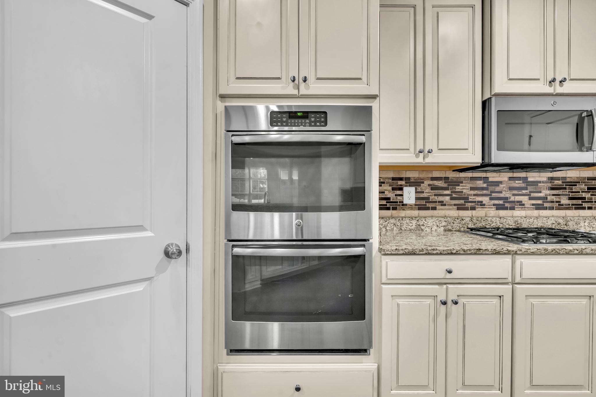 41663 McMonagle Square Aldie, VA 20105 - Photo 17 of 50 a kitchen with granite countertop white cabinets and stainless steel appliances