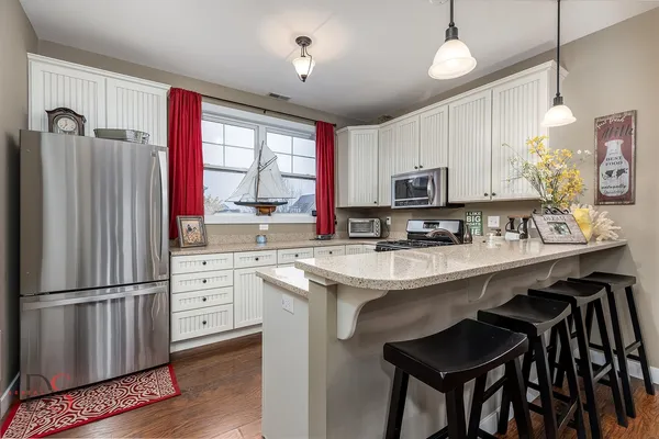 a kitchen with stainless steel appliances granite countertop a stove a sink refrigerator and microwave