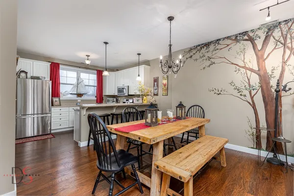 a dining room with furniture a chandelier and wooden floor