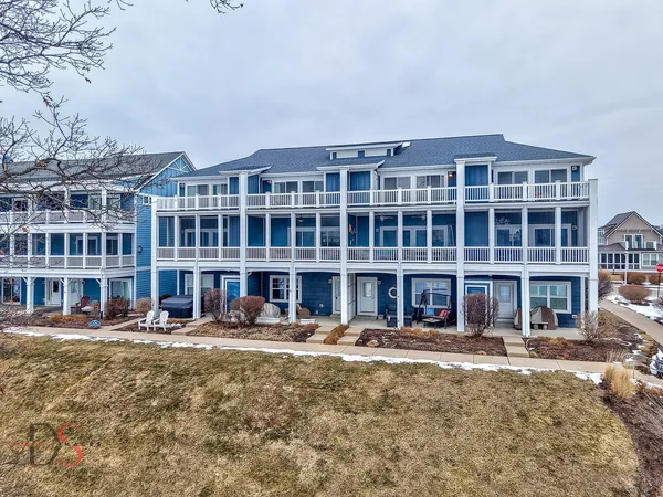 a front view of a building with street and trees