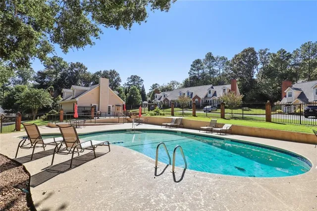 an aerial view of a house with swimming pool having outdoor seating