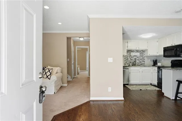 a view of a kitchen with refrigerator and wooden floor