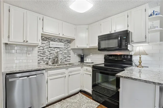 a kitchen with cabinets appliances a sink and a counter top