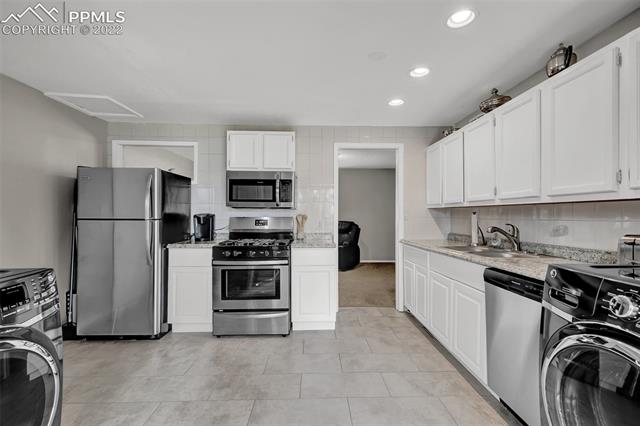 513 Huron Road Colorado Springs, CO 80910 - Photo 11 of 26 Kitchen includes laundry area with front loading washer & dryer included!