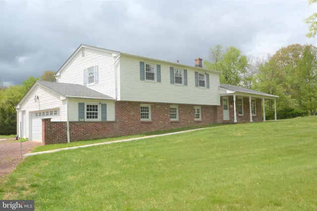 a front view of house with yard and trees in the background