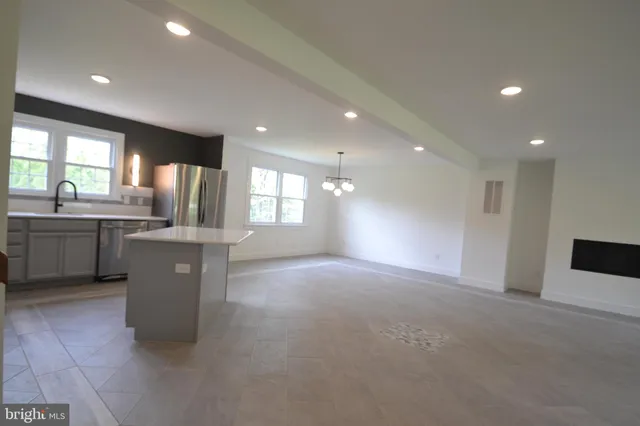 a view of a kitchen with a sink and dishwasher a refrigerator with wooden floor