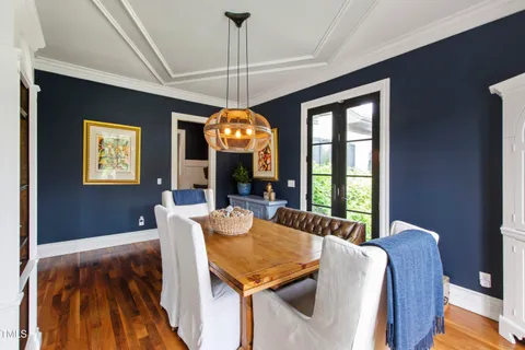 a living room with furniture large windows and wooden floor