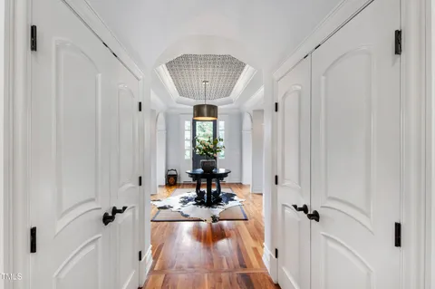 a kitchen with stainless steel appliances granite countertop a sink dishwasher stove refrigerator and couches with wooden floor