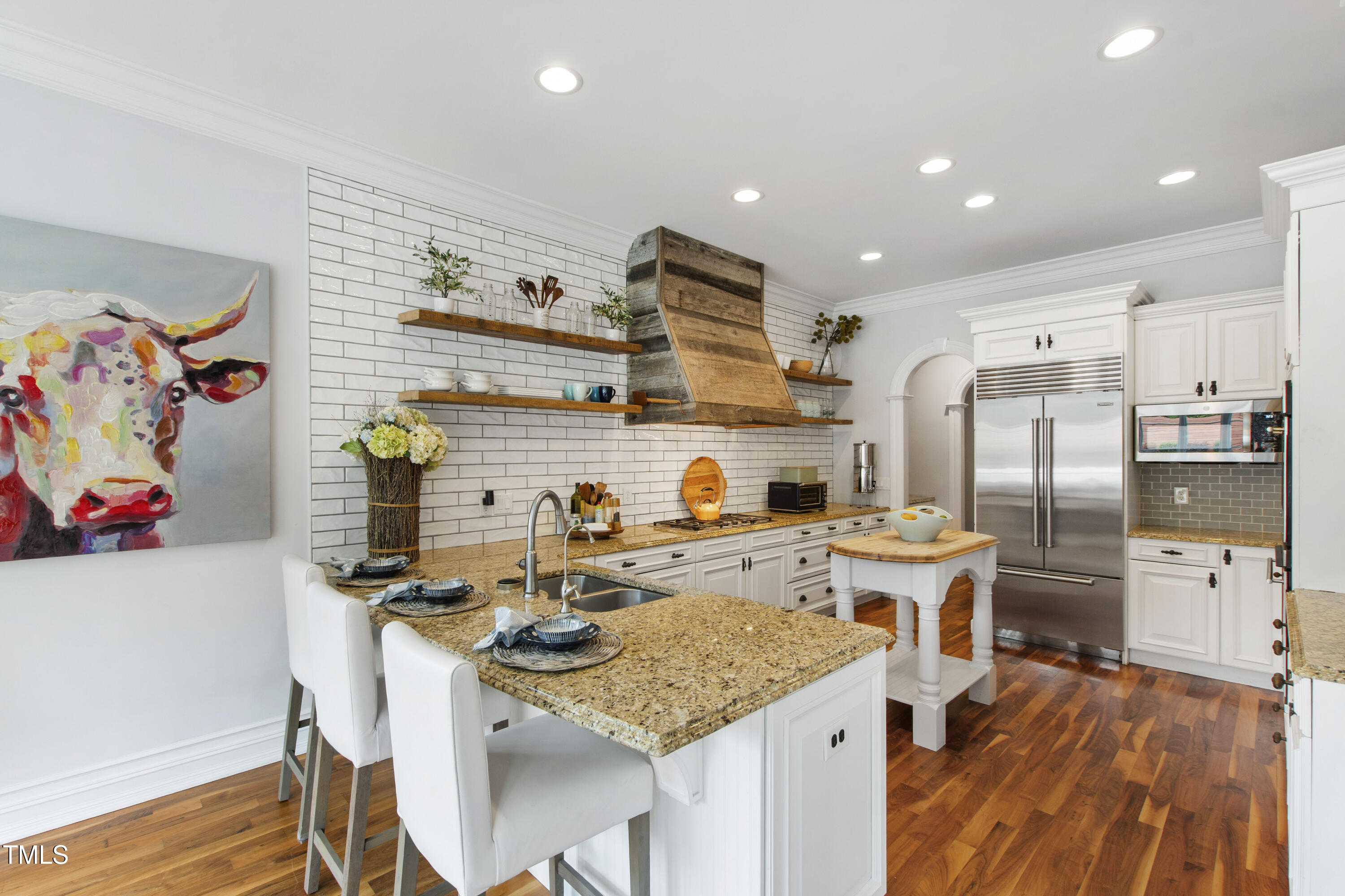 4725 Saratoga Falls Lane Raleigh, NC 27614 - Photo 21 of 97 a kitchen with stainless steel appliances granite countertop a sink dishwasher stove refrigerator and couches with wooden floor