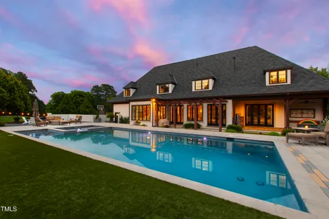 a view of a house with pool and a yard