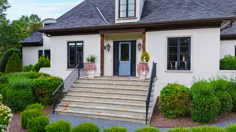 a view of a house with potted plants and a table