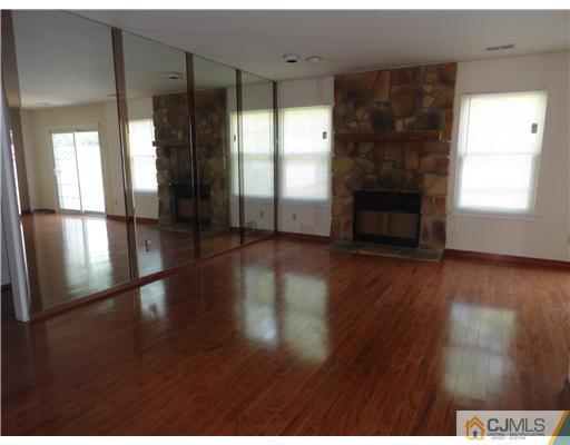 36 Woodbury Road Edison, NJ 08820 - Photo 3 of 15 a view of a living room with hardwood floor and a fireplace