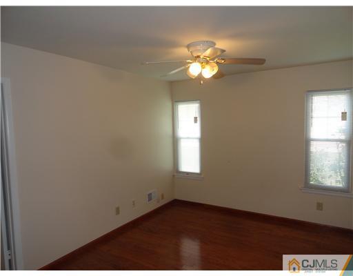 36 Woodbury Road Edison, NJ 08820 - Photo 6 of 15 an empty room with windows and chandelier fan