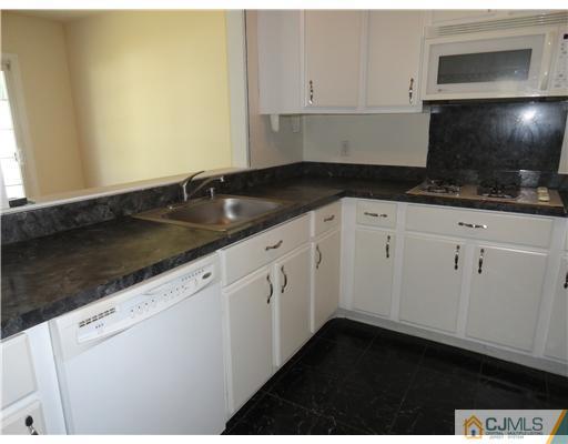 36 Woodbury Road Edison, NJ 08820 - Photo 7 of 15 a kitchen with granite countertop white cabinets and black appliances
