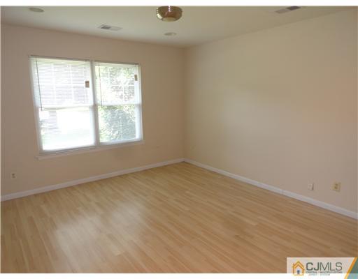 36 Woodbury Road Edison, NJ 08820 - Photo 10 of 15 an empty room with wooden floor and windows