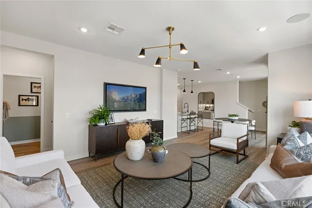 a kitchen with stainless steel appliances granite countertop a sink a stove a refrigerator cabinets and dining table