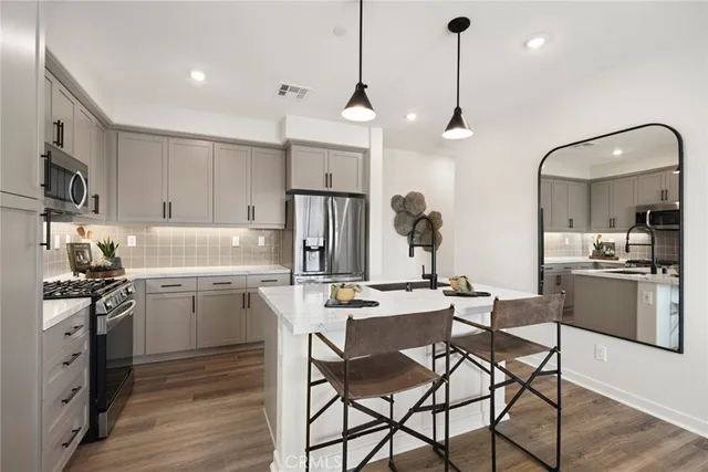 a kitchen with a dining table chairs refrigerator and cabinets