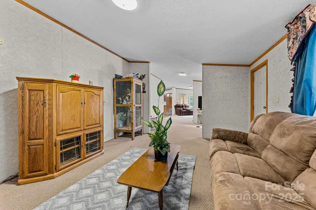 a living room with furniture a flat screen tv and a refrigerator