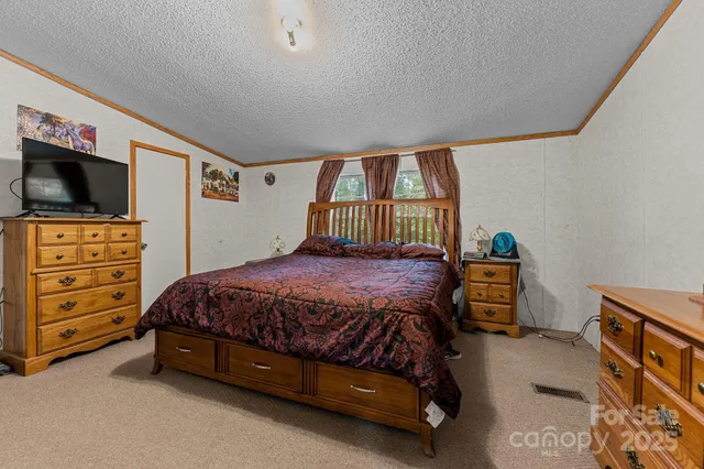 a spacious bedroom with a bed and a flat screen tv