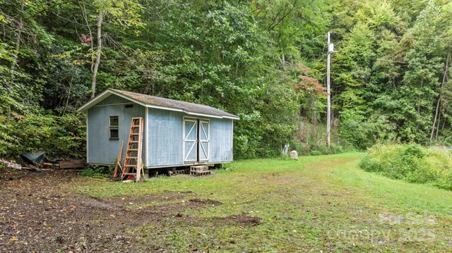 a view of a backyard with barn and wooden fence