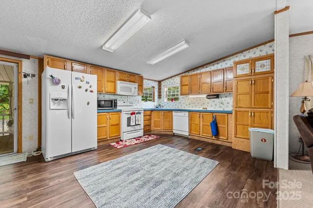 a living room with stainless steel appliances granite countertop furniture and a kitchen view