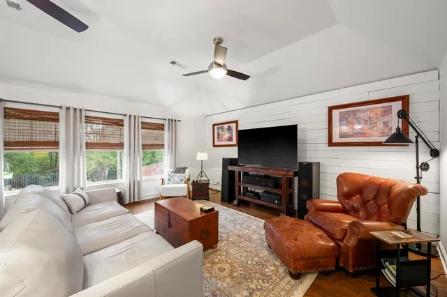 a living room with furniture a flat screen tv and a large window