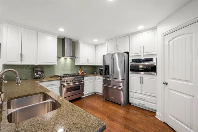 a kitchen with a refrigerator stove and white cabinets