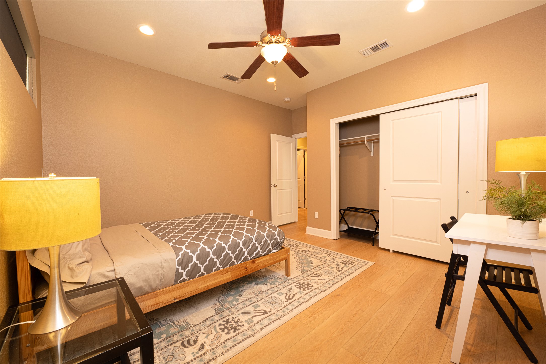 2302 East 9th Street Austin, TX 78702 - Photo 24 of 31 A cozy bedroom with a warm ambiance features recessed lighting and durable hardwood flooring.