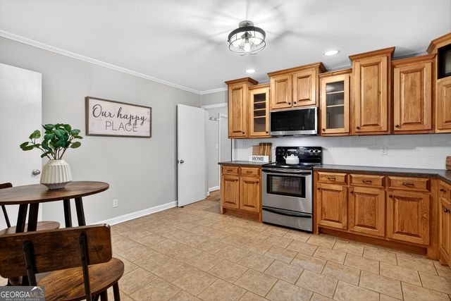 a kitchen with stainless steel appliances granite countertop a stove top oven a sink dishwasher and a microwave oven on the blue kitchen countertops