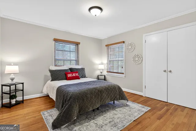 a bedroom with a bed and wooden floor