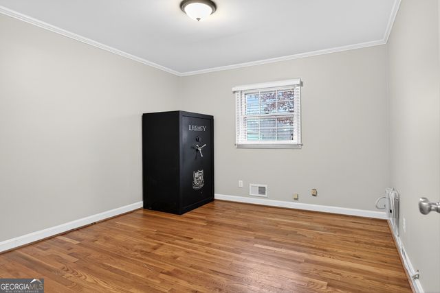 an empty room with wooden floor and window