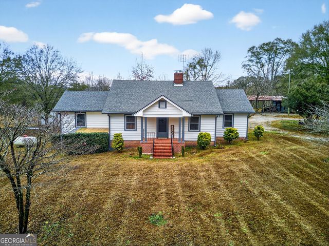 a view of a house with a yard and sitting area
