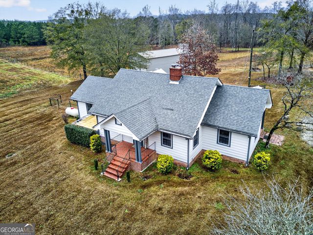 an aerial view of a house with yard and lake view
