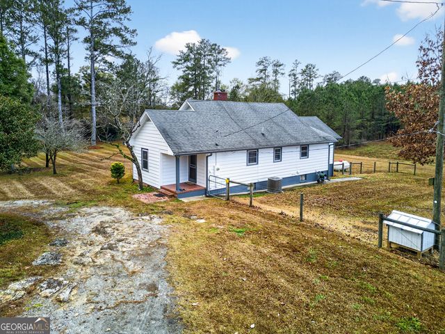 an aerial view of a house with garden space and sitting area