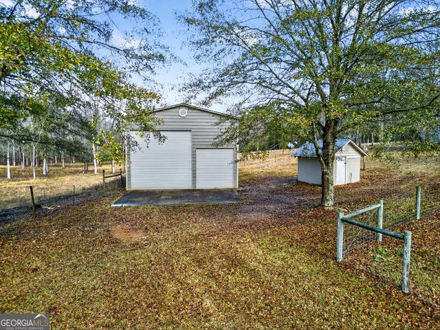 a backyard of a house with swimming pool table and chairs