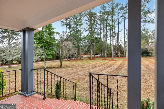 a view of a house with a yard and large tree