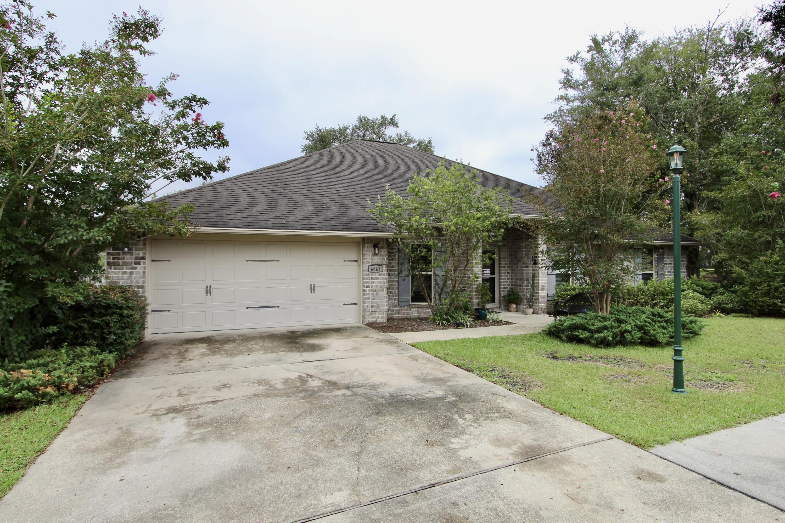 4641 Chanan Drive Crestview, FL 32539 - Photo 3 of 45 a front view of a house with a yard and garage