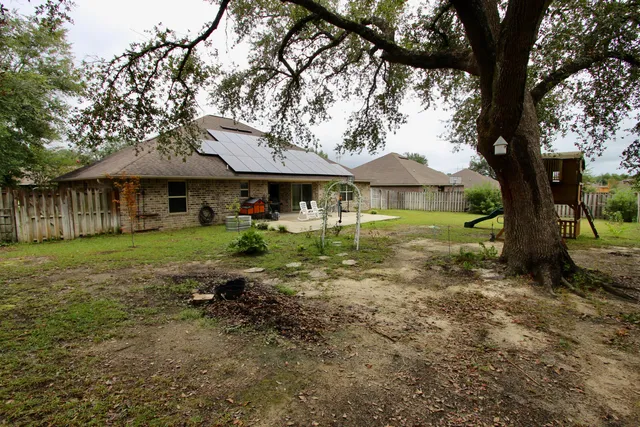 a view of a house with a patio and a garden