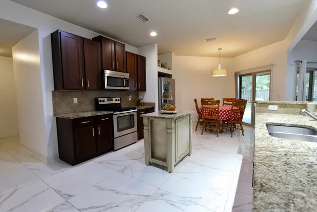 a kitchen with stainless steel appliances granite countertop wooden cabinets a stove top oven a sink and dishwasher