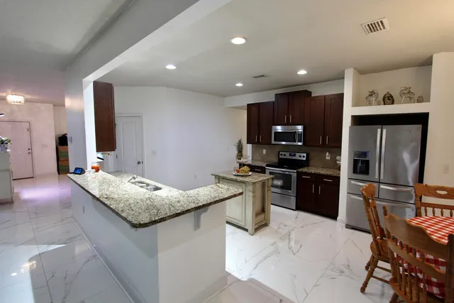 a kitchen with stainless steel appliances granite countertop granite counter tops refrigerator and stove