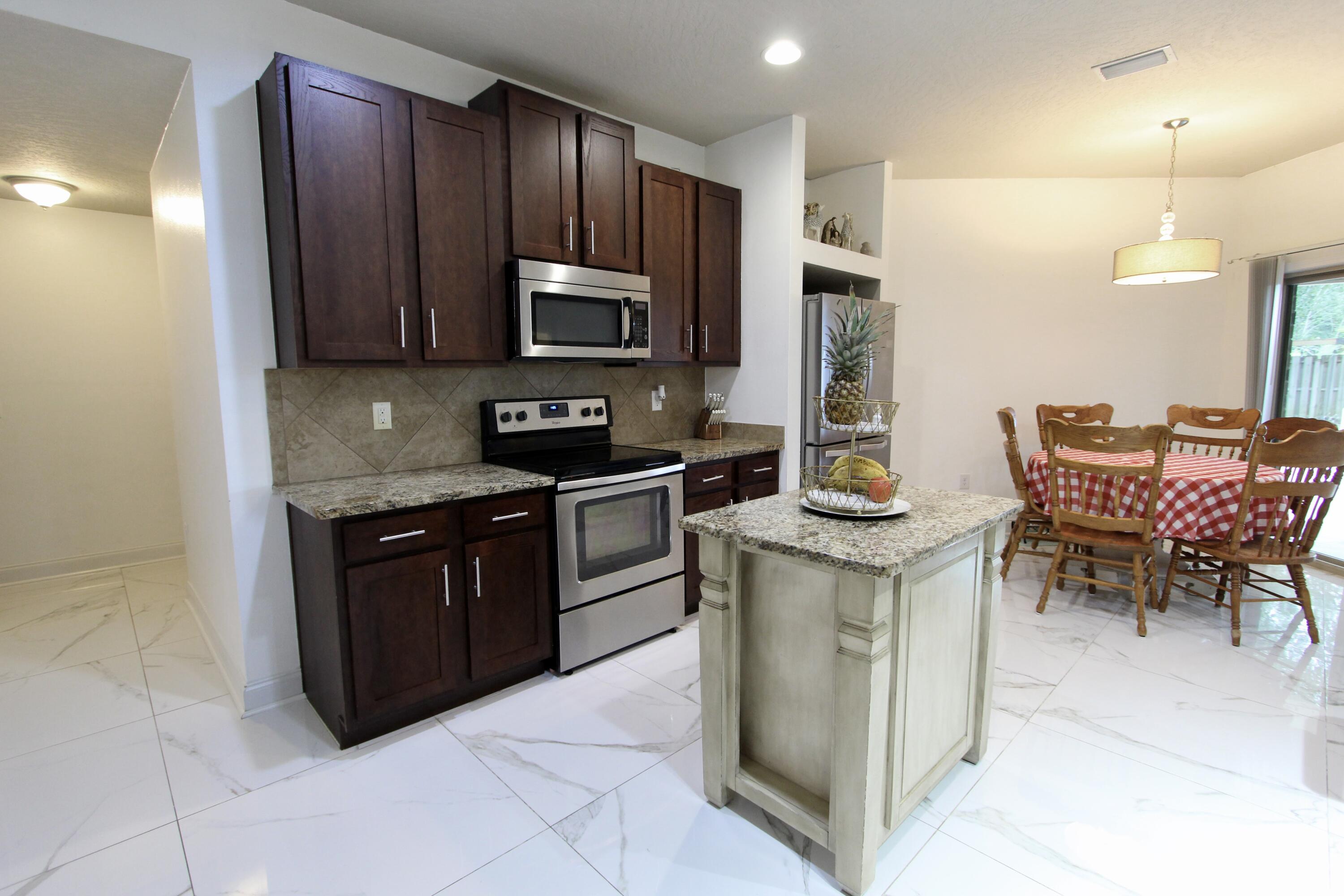 4641 Chanan Drive Crestview, FL 32539 - Photo 8 of 45 a kitchen with stainless steel appliances granite countertop a stove a sink a microwave and a refrigerator