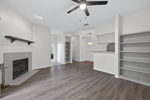 a view of empty room with wooden floor fireplace and windows