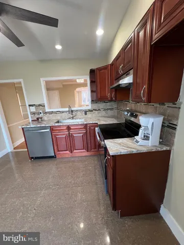 a kitchen with stainless steel appliances granite countertop a stove top oven a sink dishwasher and a microwave oven on the blue kitchen countertops